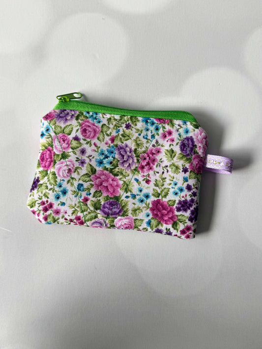 Purple flower coin wallet with a green zipper, perfect for storing coins and small items.