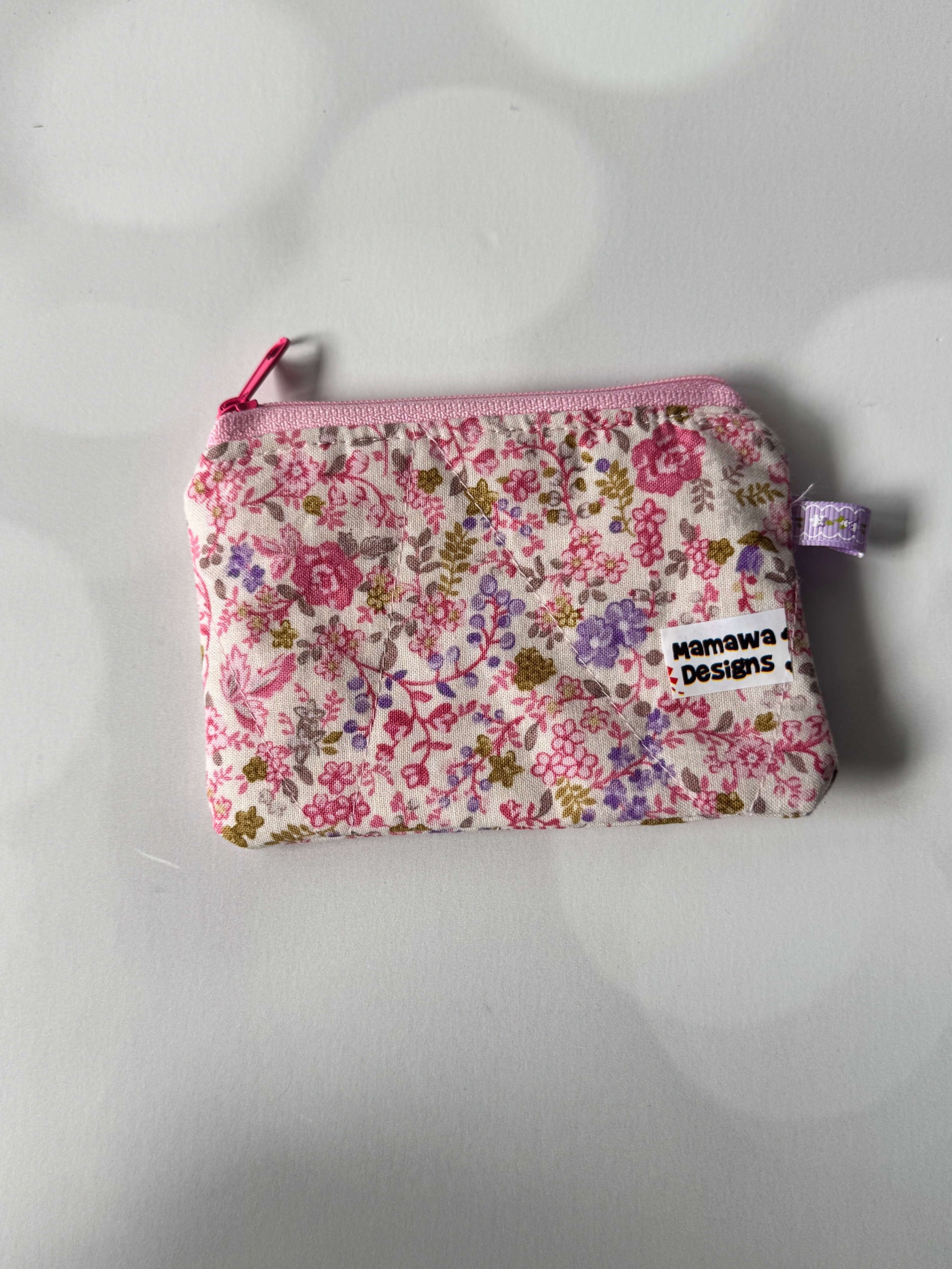 Pink floral coin wallet featuring a colorful design by Manawa Designs, perfect for storing coins and small essentials.