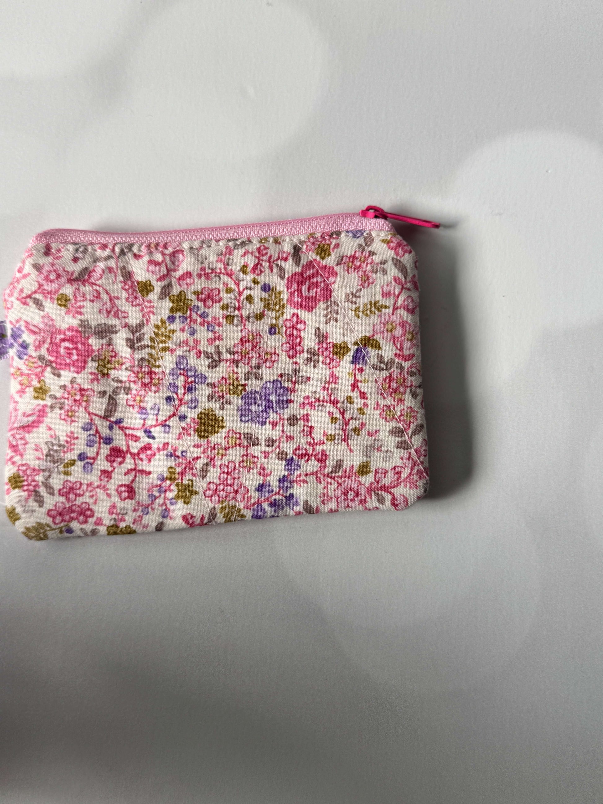 Pink floral coin wallet, compact and stylish, perfect for storing coins and small essentials.
